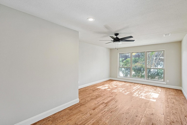 empty room with ceiling fan, a textured ceiling, and light hardwood / wood-style flooring