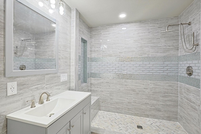 bathroom with tiled shower, decorative backsplash, vanity, and tile walls