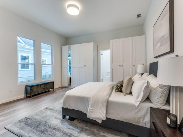 bedroom featuring light hardwood / wood-style floors and ensuite bath