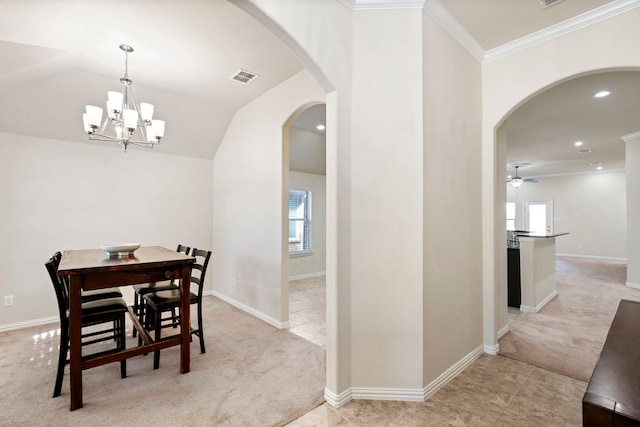 dining room with lofted ceiling, ceiling fan with notable chandelier, light colored carpet, and crown molding