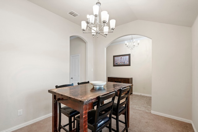 carpeted dining area featuring vaulted ceiling and a notable chandelier