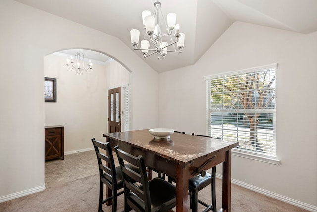 dining area with light carpet, plenty of natural light, and vaulted ceiling