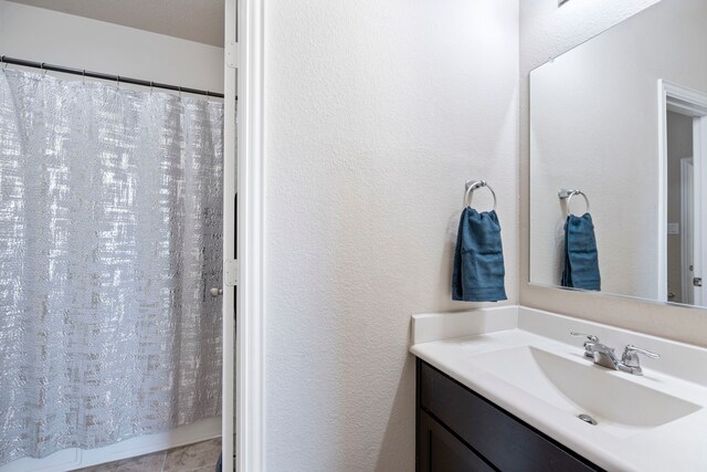 bathroom with a shower with shower curtain and vanity