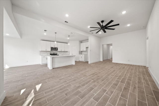 unfurnished living room with ceiling fan and light hardwood / wood-style floors