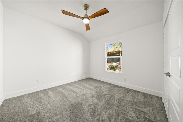 carpeted spare room featuring ceiling fan and lofted ceiling