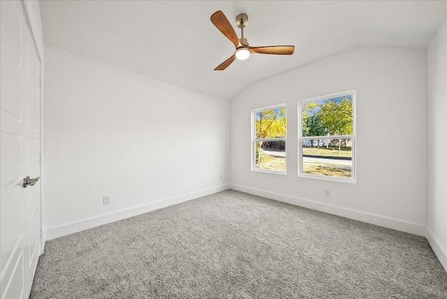 empty room featuring ceiling fan, lofted ceiling, and carpet floors