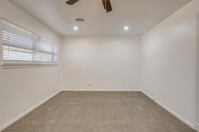 carpeted spare room featuring ceiling fan