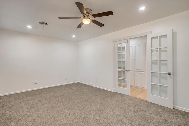 carpeted empty room featuring ceiling fan and french doors