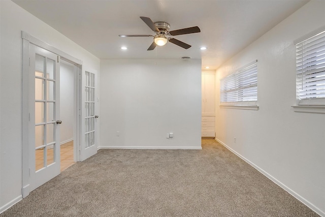 empty room with light carpet, french doors, and ceiling fan