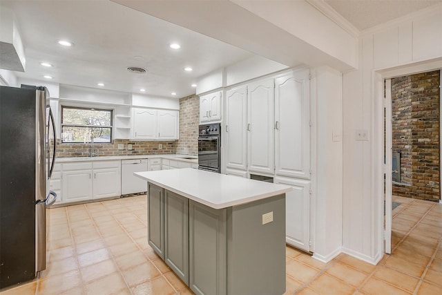 kitchen featuring stainless steel fridge, ornamental molding, a kitchen island, dishwasher, and white cabinetry