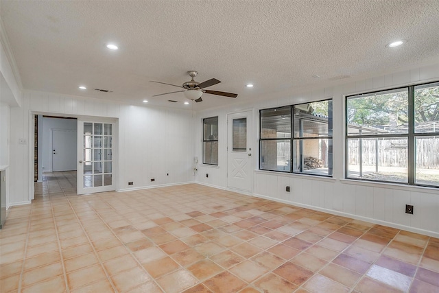 empty room featuring ceiling fan, light tile patterned floors, and a textured ceiling