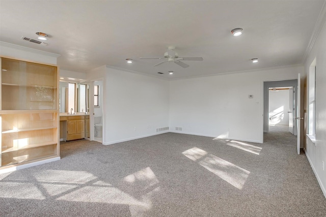 unfurnished living room with carpet, ceiling fan, sink, and crown molding