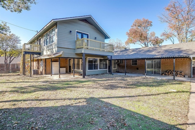 back of property with a lawn, a balcony, and a patio