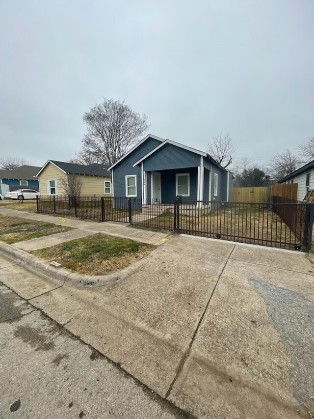 bungalow featuring covered porch and a front yard