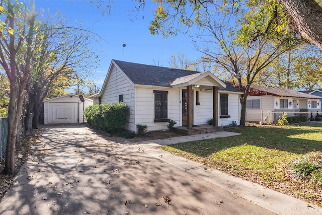 view of front of house featuring a front yard and a shed