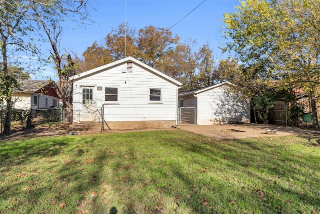 back of house with a patio area and a lawn