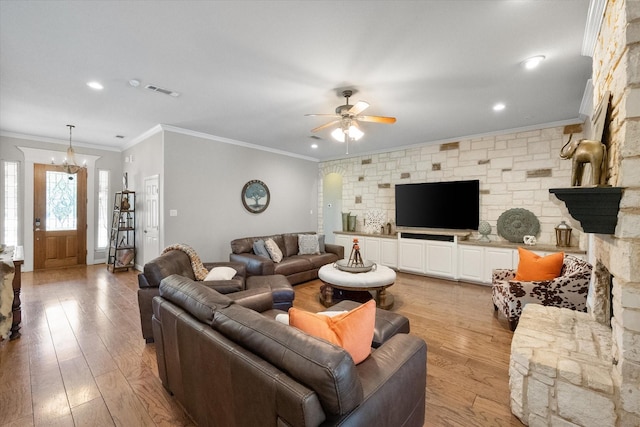 living room featuring ceiling fan with notable chandelier, light hardwood / wood-style flooring, and ornamental molding