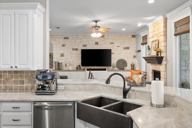 kitchen with white cabinetry, dishwasher, sink, and light stone counters