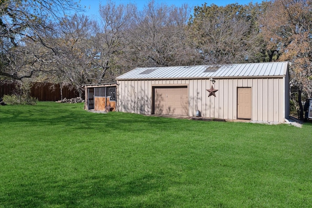 view of outdoor structure with a garage and a lawn