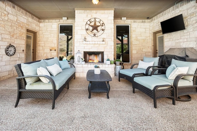 living room featuring an outdoor fireplace and carpet flooring