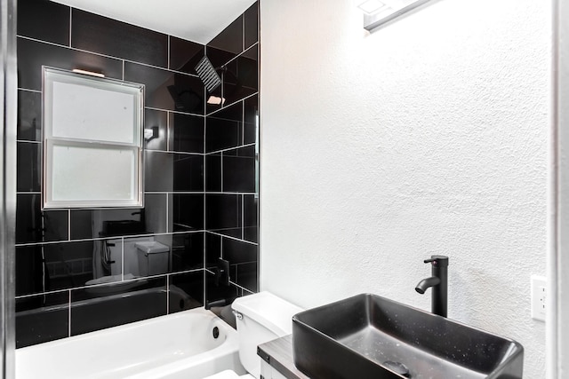 full bathroom with tiled shower / bath combo, sink, and toilet