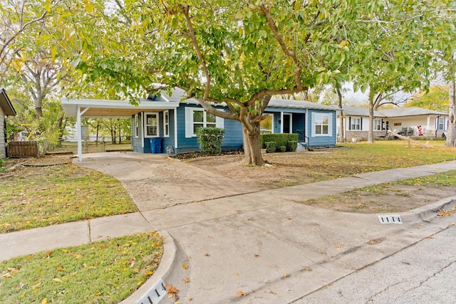 view of front of property with a carport and a front lawn