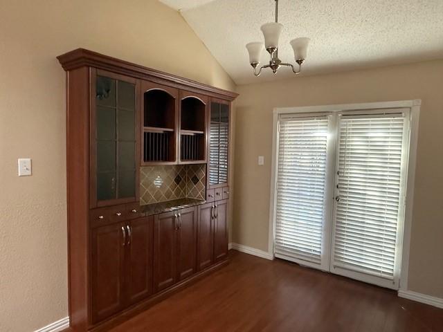 spare room featuring wood-type flooring, a textured ceiling, vaulted ceiling, and ceiling fan