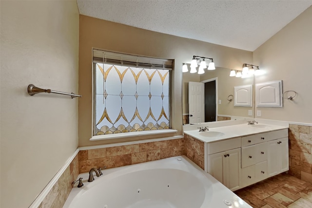 bathroom featuring vanity, a textured ceiling, and a bathtub