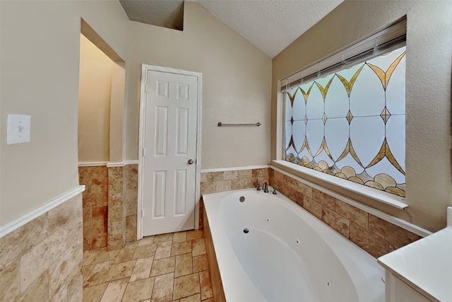 bathroom featuring a textured ceiling, a bathtub, vaulted ceiling, and tile patterned flooring