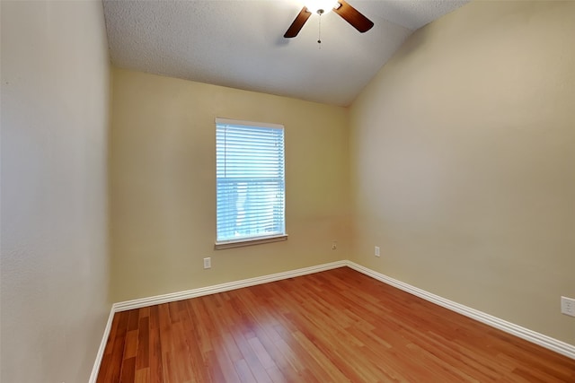 spare room featuring a textured ceiling, ceiling fan, lofted ceiling, and hardwood / wood-style flooring