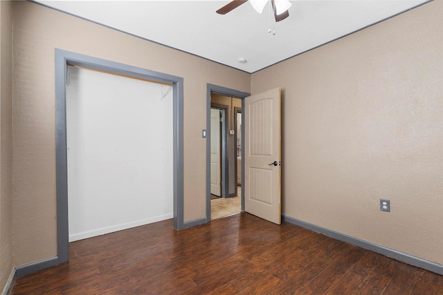 unfurnished bedroom with ceiling fan and dark wood-type flooring