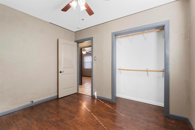 unfurnished bedroom featuring a closet, dark hardwood / wood-style floors, and ceiling fan