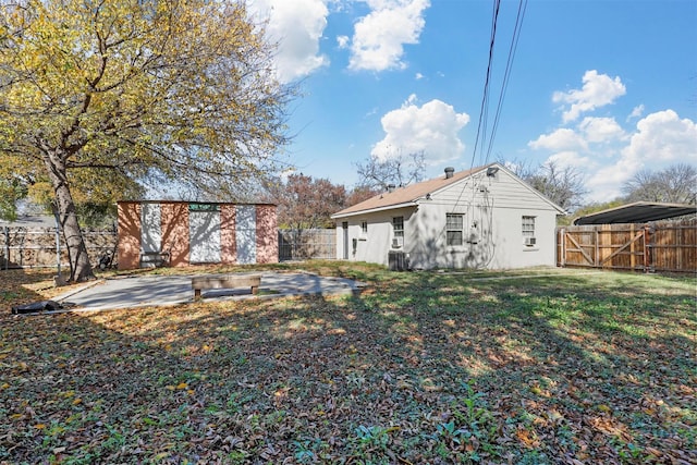 rear view of property with a patio area, a yard, and central air condition unit