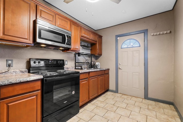 kitchen with ceiling fan, light stone counters, sink, and black / electric stove