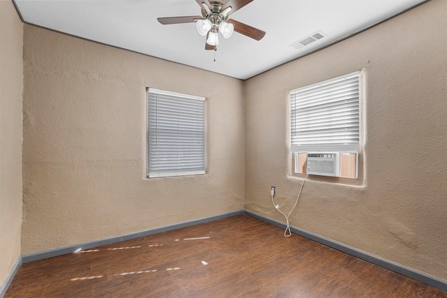 unfurnished room featuring dark hardwood / wood-style floors, cooling unit, and ceiling fan