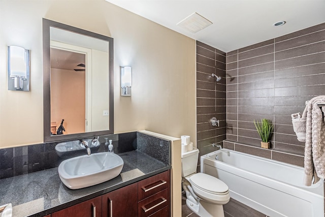 full bathroom with tiled shower / bath combo, toilet, and vanity