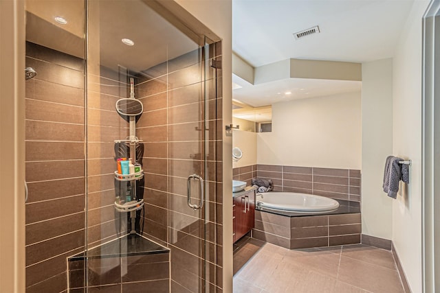 bathroom featuring tile patterned flooring, vanity, and shower with separate bathtub