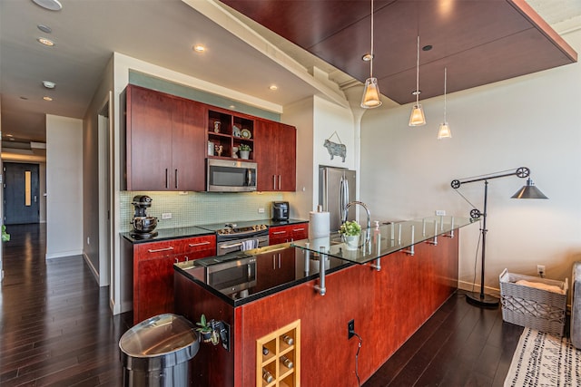 kitchen with backsplash, stainless steel appliances, dark hardwood / wood-style floors, a kitchen bar, and decorative light fixtures