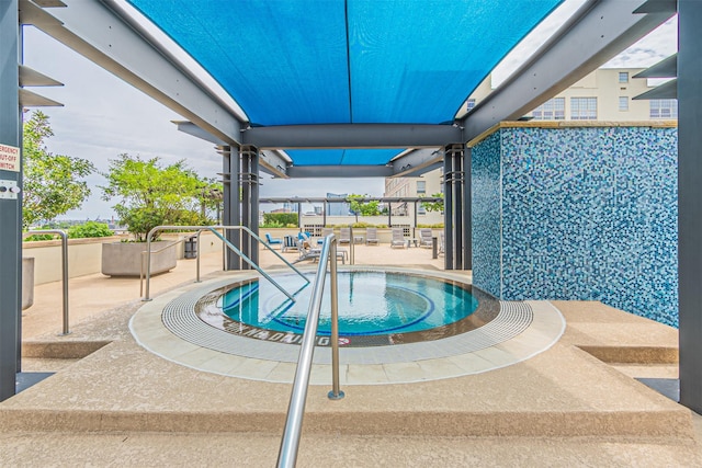 view of pool featuring a patio area and an in ground hot tub