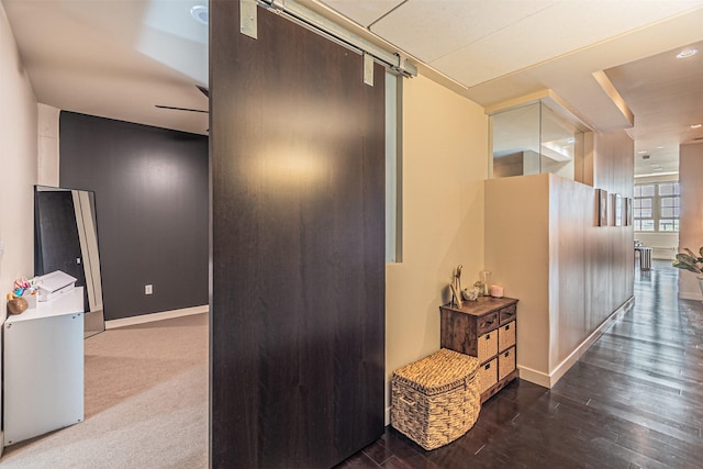 corridor featuring dark hardwood / wood-style flooring and a barn door