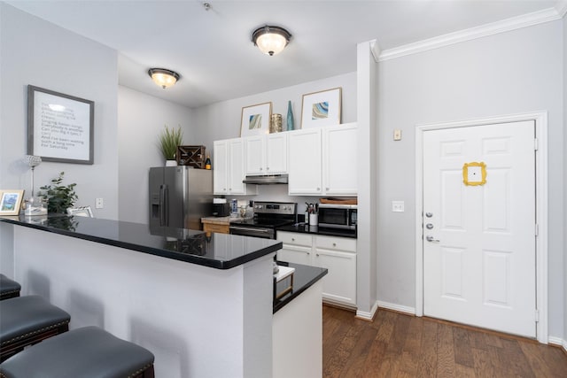 kitchen featuring stainless steel appliances, a breakfast bar, white cabinets, and kitchen peninsula