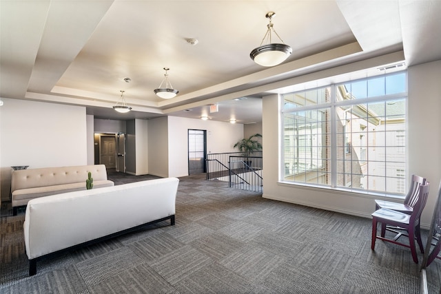 living room with dark carpet and a raised ceiling