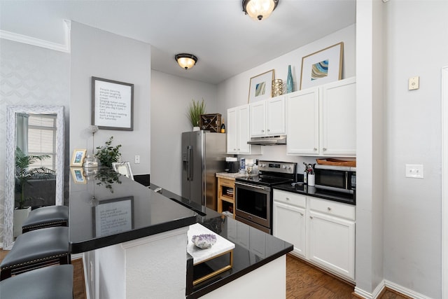 kitchen with a breakfast bar, dark wood-type flooring, white cabinets, sink, and stainless steel appliances