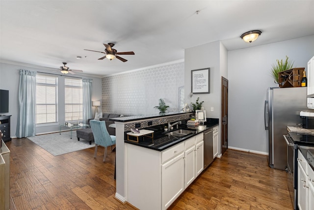 kitchen featuring dark hardwood / wood-style flooring, white cabinetry, sink, and appliances with stainless steel finishes