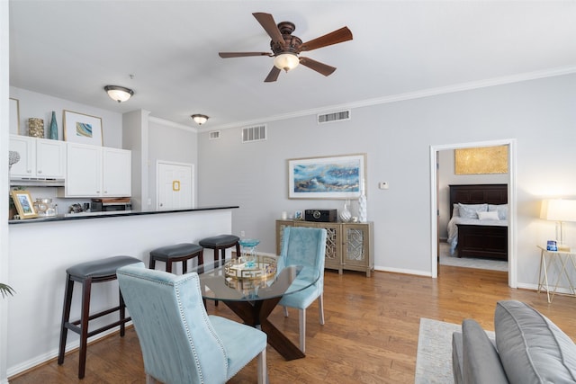 dining space featuring crown molding, ceiling fan, and light wood-type flooring