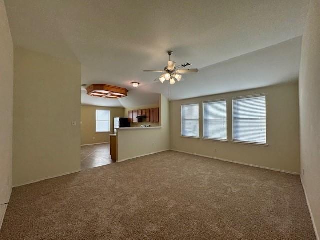 unfurnished living room with carpet, vaulted ceiling, and ceiling fan