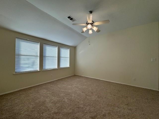 empty room featuring ceiling fan, carpet floors, and lofted ceiling