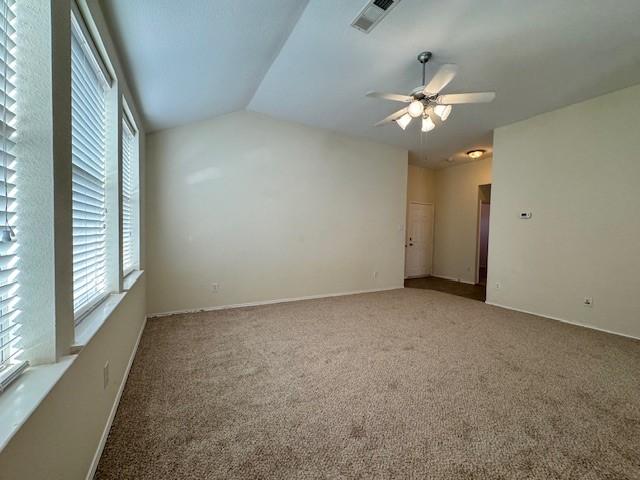 carpeted empty room with ceiling fan and lofted ceiling