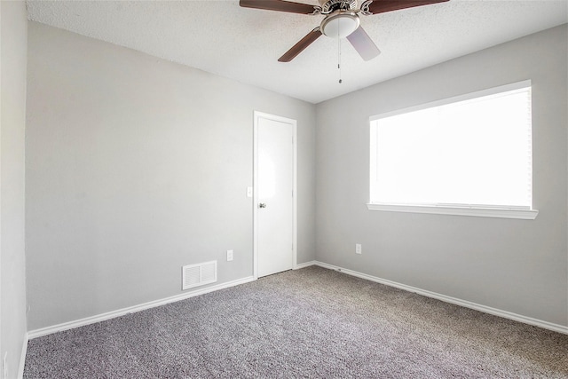 empty room featuring ceiling fan, carpet floors, and a textured ceiling