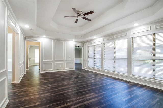 unfurnished bedroom featuring ceiling fan, a tray ceiling, and dark hardwood / wood-style flooring